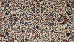 tappeto persiano kashan, con motivi floreali e arabeschi intricati, colori intensi come rosso, blu e avorio