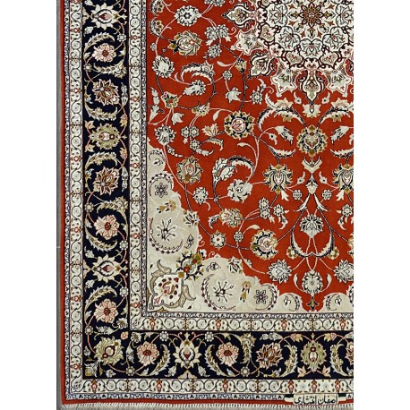 dettaglio di tappeto persiano Isfahan con medaglione centrale, dettagli anturalistici intricati e arabescati e colori brillanti rosso, blu, beige e avorio