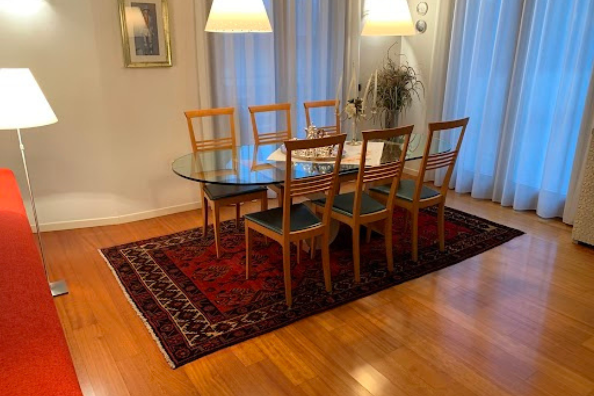 Tappeto sala da pranzo Tappeto classico persiano di Adamello Tappeti posto in una sala da pranzo sotto un tavolo di vetro con sei sedie