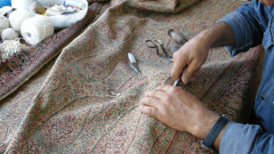 restauro tappeti a mano persona che effettua un restauro a un tappeto